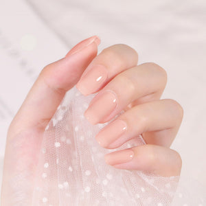 Peach pink gel nail polish applied on well-groomed nails with a glossy finish, showcasing soft peach tones.
